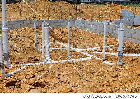 Installation of utility pipes water pipes under foundation of new home and laying sewer pipes for utilities 100074769