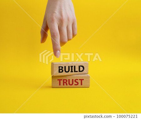 Build trust symbol. Wooden blocks with words Build trust. Beautiful yellow background. Businessman hand. Business and Build trust concept. Copy space. Build trust symbol. Wooden blocks with words Build trust. Beautiful yellow background. Businessman hand. Business and Build trust concept. Copy space. 100075221