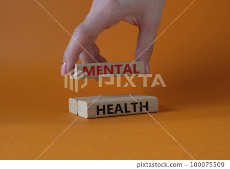 Mental health symbol. Wooden blocks with words Mental health. Businessman hand. Beautiful orange background. Business and Mental health concept. Copy space. 100075509
