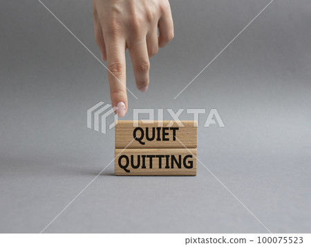Quiet quitting symbol. Concept word Quiet quitting on wooden blocks. Beautiful grey background. Businessman hand. Business and Quiet quitting concept. Copy space. Quiet quitting symbol. Concept word Quiet quitting on wooden blocks. Beautiful grey background. Businessman hand. Business and Quiet quitting concept. Copy space. 100075523