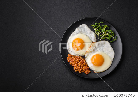 Delicious hearty breakfast consisting of two fried eggs, canned lentils and microgreens 100075749