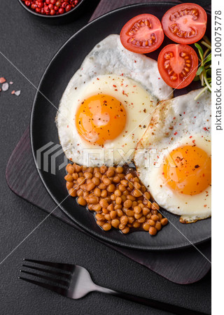 Delicious hearty breakfast consisting of two fried eggs, canned lentils and microgreens 100075778