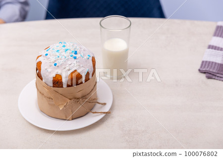 An Easter cake and a glass glass with milk are on the table. An Easter cake and a glass glass with milk are on the table. 100076802