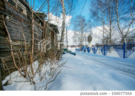 A house with a collapsed roof and walls next to the monument.  about the epic hero Ilya Muromets in Muromek as a symbol of what is happening in Russia 100077568