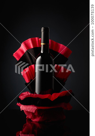Bottle of red wine on a crumpled paper. 100078139