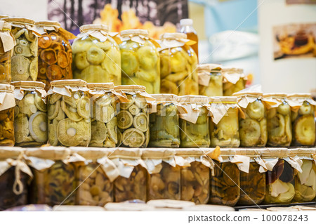 Glass jar rows with marinated, salted mushrooms, prepared by farmer. Preserving Organic Vegetables Glass jar rows with marinated, salted mushrooms, prepared by farmer. Preserving Organic Vegetables 100078243