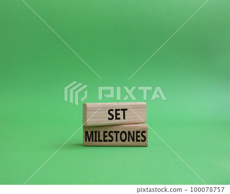Set milestones symbol. Concept word Set milestones on wooden blocks. Beautiful green background. Business and Set milestones concept. Copy space Set milestones symbol. Concept word Set milestones on wooden blocks. Beautiful green background. Business and Set milestones concept. Copy space 100078757