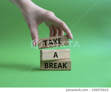 Take a break symbol. Concept words 'Take a break' on wooden blocks. Beautiful green background. Businessman hand. Business and Take a break concept. Copy space. 100078820