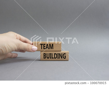 Team Building symbol. Concept word Team Building on wooden blocks. Beautiful grey background. Businessman hand. Business and Team Building concept. Copy space 100078915