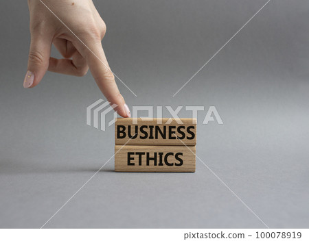 Business ethics symbol. Concept word Business ethics on wooden blocks. Beautiful grey background. Businessman hand. Business and Business ethics concept. Copy space Business ethics symbol. Concept word Business ethics on wooden blocks. Beautiful grey background. Businessman hand. Business and Business ethics concept. Copy space 100078919