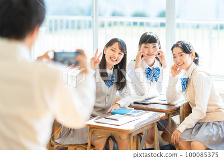 High school girl taking a picture with a smartphone in the classroom 100085375