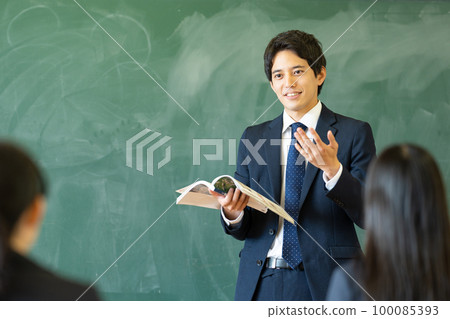 Male teacher teaching in a classroom 100085393