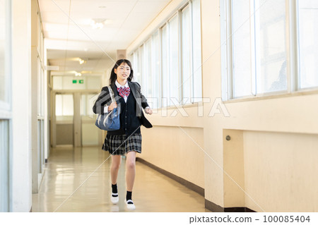 High school girl running in the school corridor 100085404