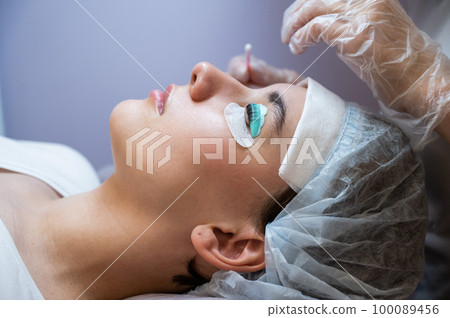 Close-up portrait of a woman on eyelash lamination procedure. Close-up portrait of a woman on eyelash lamination procedure. 100089456