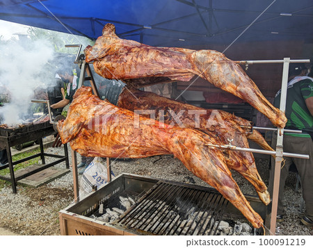 Three goats are being roasted at a wedding. Three goats are being roasted at a wedding. 100091219