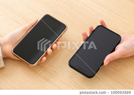 Young woman's hand holding a smartphone Young woman's hand holding a smartphone 100093889