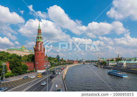 View of Kremlin with Vodovzvodnaya tower, Grand Kremlin Palace from repaired Bolshoy Kamenny Bridge in Moscow city on sunny summer day. Cruise ship sails on the Moscow river 100095853