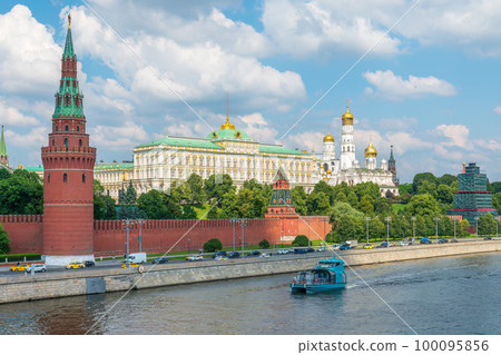 View of Kremlin with Vodovzvodnaya tower, Grand Kremlin Palace from repaired Bolshoy Kamenny Bridge in Moscow city on sunny summer day. Cruise ship sails on the Moscow river 100095856