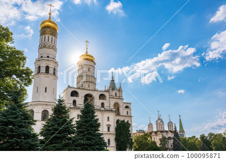 Ivan the Great Bell Tower, with Assumption Belfry on the right in Moscow Kremlin. Blue sky background with sunbeams 100095871