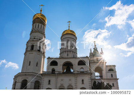 Ivan the Great Bell Tower, with Assumption Belfry on the right in Moscow Kremlin. Blue sky background with sunbeams 100095872