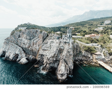 Crimea Swallow's Nest Castle on the rock over the Black Sea. It is a tourist attraction of Crimea. Amazing aerial view of the Crimea coast with the castle above abyss on sunny day. 100096569