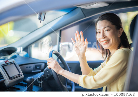 A middle woman who stops the car and waves her hand A middle woman who stops the car and waves her hand 100097168