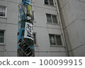 Pillars and buildings with lots of stickers on them 100099915