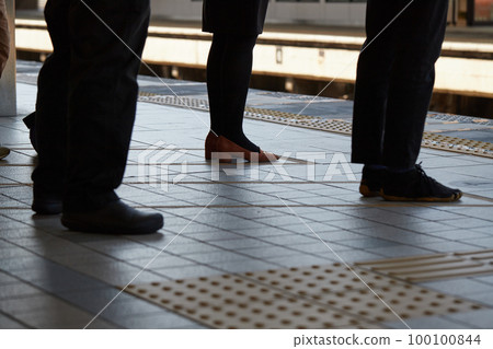 The state of the feet of male and female passengers lined up on the platform of the station during the morning commute 100100844