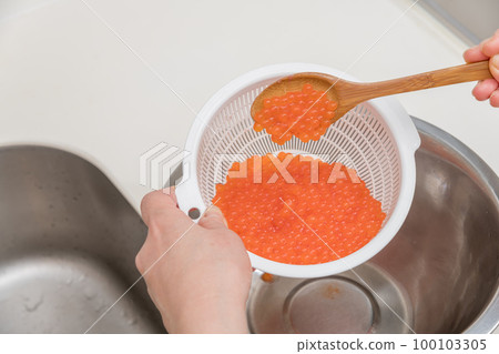 [製作醬油醃製三文魚子，用勺子將洗淨的生三文魚子與清酒混合] 100103305