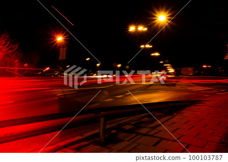 Lights of cars at night. Street line lights. Night highway city. Long exposure photograph night road. Colored bands of red light trails on the road. Background wallpaper defocused blurred Lights of cars at night. Street line lights. Night highway city. Long exposure photograph night road. Colored bands of red light trails on the road. Background wallpaper defocused blurred 100103787