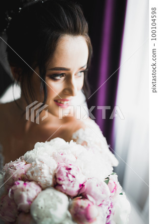 Bride holding big and beautiful wedding bouquet with flowers Bride holding big and beautiful wedding bouquet with flowers 100104598