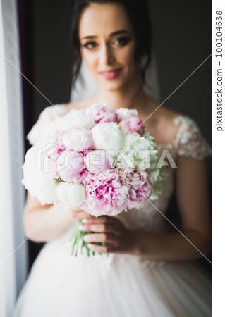 Bride holding big and beautiful wedding bouquet with flowers Bride holding big and beautiful wedding bouquet with flowers 100104638