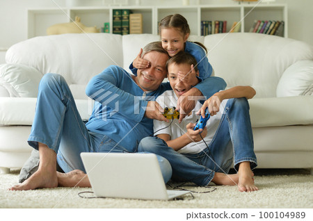 dad and kids have fun playing with a laptop dad and kids have fun playing with a laptop 100104989