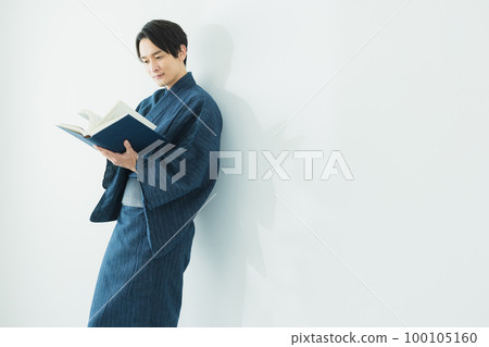 man in yukata reading man in yukata reading 100105160