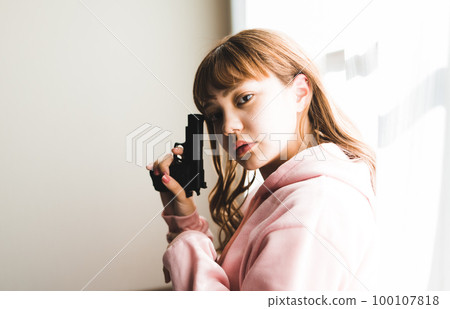A scene like a movie of a woman holding a gun 100107818