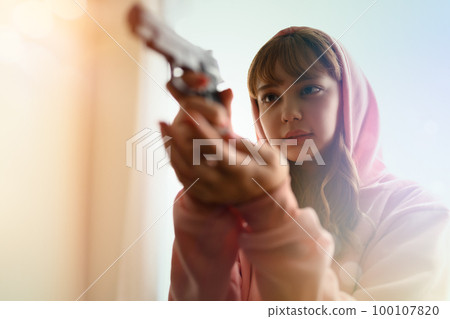 A scene like a movie of a woman holding a gun 100107820