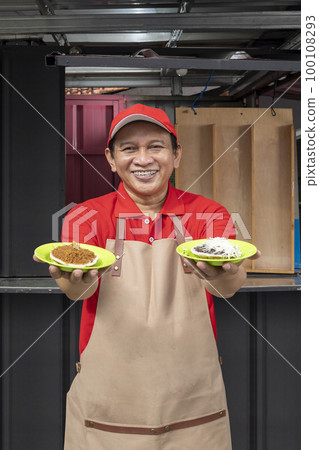 Asian man with a hat and apron showing serabi Asian man with a hat and apron showing serabi 100108293