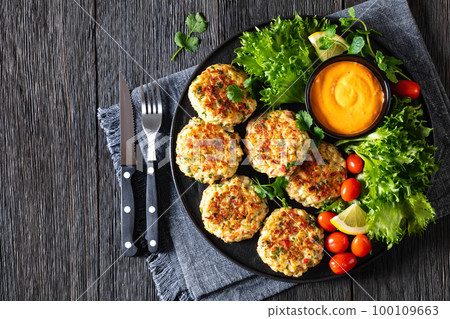 crab cakes with sauce, lettuce, tomatoes, lemon 100109663