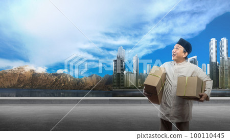 Asian Muslim man carrying box ready to mudik on the street 100110445