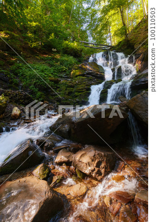 waterfall among wet rocks. fresh environment and clear water concept. summer nature scenery waterfall among wet rocks. fresh environment and clear water concept. summer nature scenery 100110503