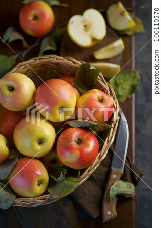 Ripe apples in a basket, with leaves around it 100110570