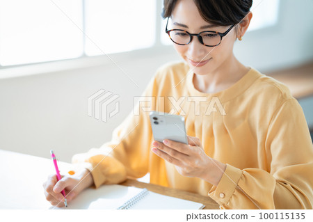 Middle-aged woman studying with a smartphone 100115135