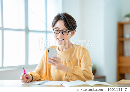 Middle-aged woman studying with a smartphone 100115147