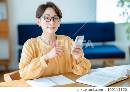Middle-aged woman studying with a smartphone 100115160