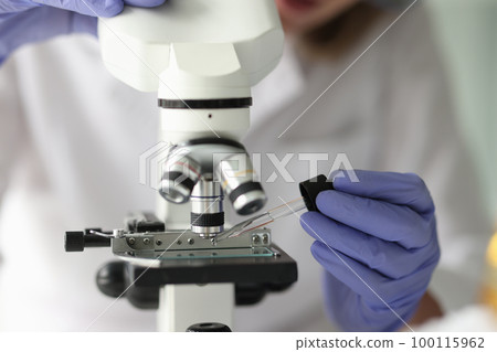 Scientist works with pipette and microscope in research laboratory. 100115962