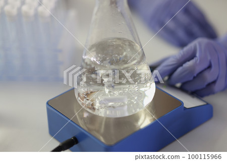 Close-up of flask with boiling liquid on heater in research laboratory. 100115966