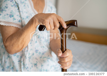 Asian elderly disability woman holding waling stick, wood cane, round handle, walking aid for help to walk. Asian elderly disability woman holding waling stick, wood cane, round handle, walking aid for help to walk. 100116377