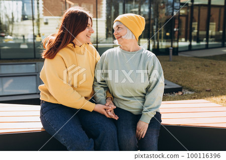 Happy friends holding each other. Happy loving older mature mother and grown millennial daughter laughing embracing, caring young woman embracing senior middle aged mom spending time together Happy friends holding each other. Happy loving older mature mother and grown millennial daughter laughing embracing, caring young woman embracing senior middle aged mom spending time together 100116396