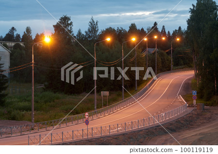 S-bend of a highway illuminated by street lamps at dusk 100119119