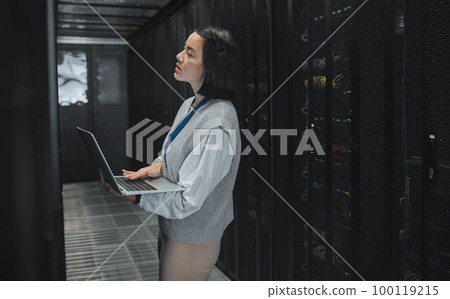 Server room, laptop and young woman or technician in data center management, system and cyber security. Thinking, serious and inspection of asian electrician, engineer or programmer person code check 100119215
